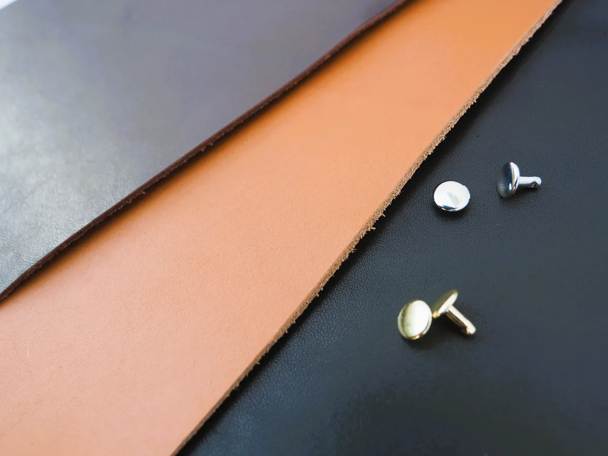 Tan, chocolate and black leather swatches with silver and gold rivets, the options buyers choose from in the configurator